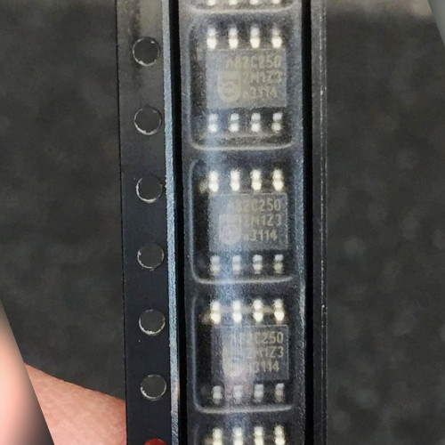 Row of small 8-lead SO chips marked 82C250, held at an angle between fingers