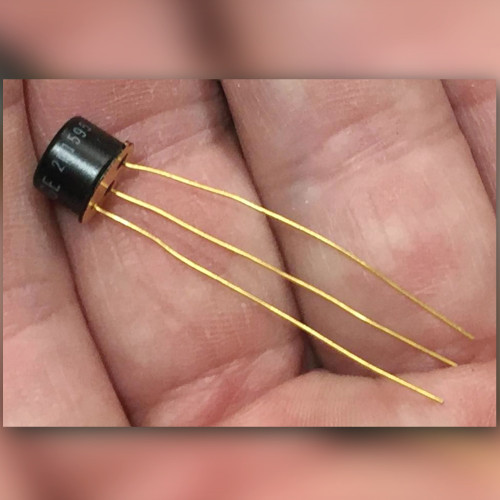 GE 2N1595 SCR in black TO-39 can with three long gold leads, held in palm.