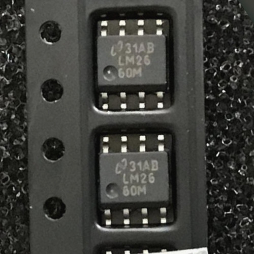 Two National LM26 60M SOIC-8 chips in black carrier tape, cover tape partly peeled