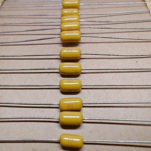 SA305C334MAA axial ceramic capacitors with yellow coated bodies mounted on tape.