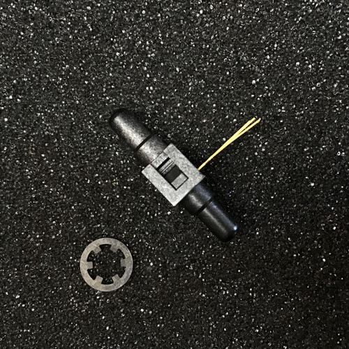 Honeywell Pressure Sensor 26PCAFA6D from PartsMine.com lying on a textured black surface with a separate metal retaining ring placed nearby. The sensor is a compact black component with a few protruding golden pins for connectivity.