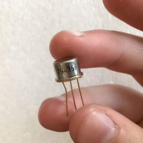Hand holds the ASI 2N4356 PNP transistor, showing the metallic casing, model number, and three gold leads.