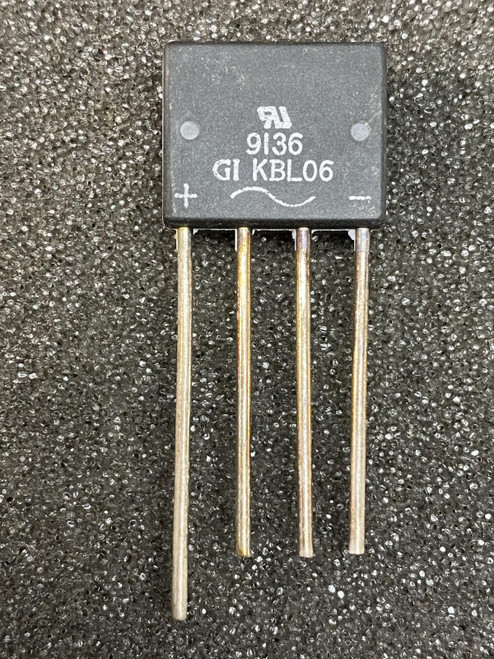 Flat-pack body marked UL, 9136, GI KBL06 with + and - polarity labels; four straight leads, no visible damage.