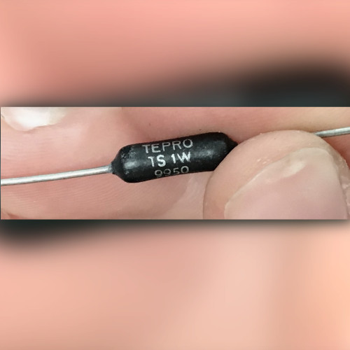 Fingers hold black axial resistor printed TEPRO, TS 1W, and 9950 in white