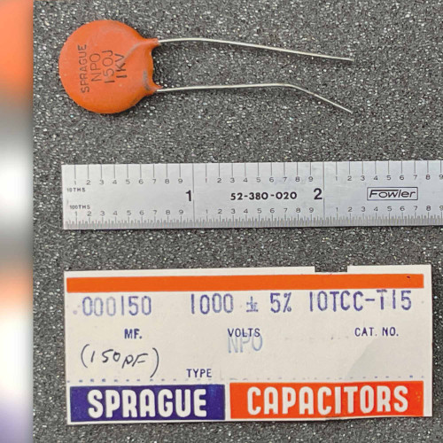 Orange Sprague ceramic disc capacitor with steel rule and Sprague carton label marked 10TCC-T15