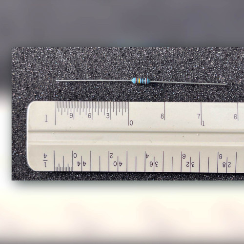 Light blue axial resistor with color bands and bright silver-colored leads on dark speckled mat