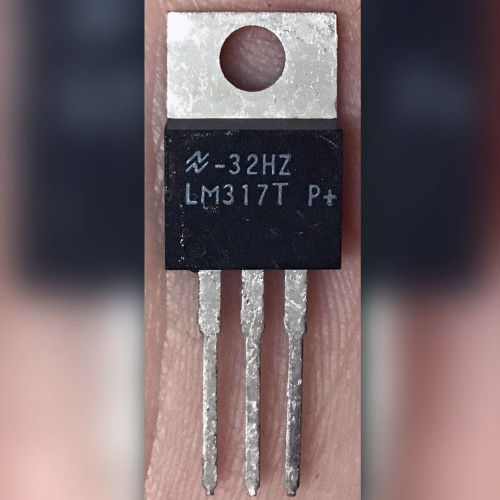 National Semiconductor LM317T TO-220 regulator held in hand, metal tab and LM317T P+ marking visible