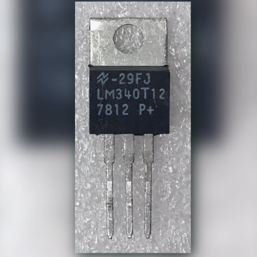 Front view of LM340T12 TO-220 regulator, markings legible, three straight untrimmed leads