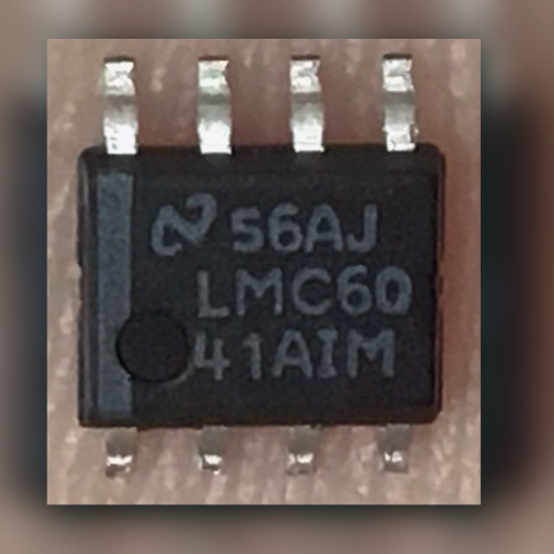 National Semiconductor LMC6041AIM SOIC-8 op amp held in fingers, top marking 56AJ visible