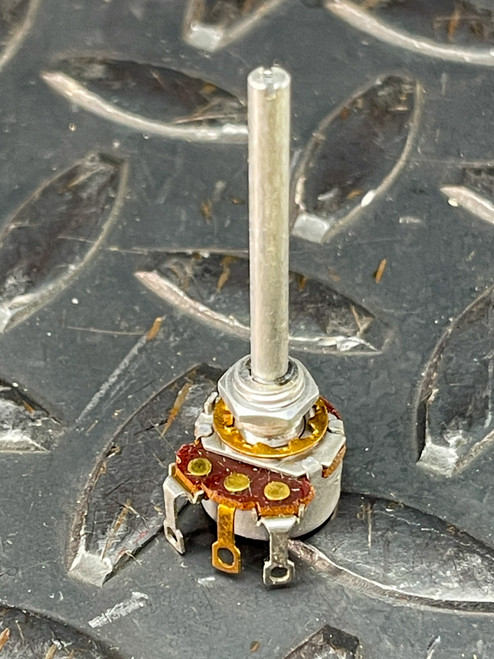 Potentiometer showing clean body, straight solder lugs, threaded bushing, and round slotted metal shaft.