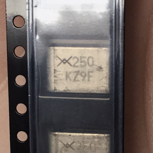 Close-up of two taped SMD250 bodies marked with crossed PolySwitch logo, 250 and KZ9F