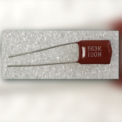 Radial dipped film capacitor marked 563K 100N.