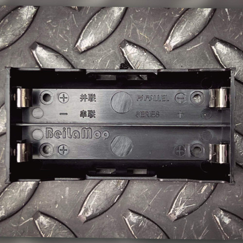Black plastic 2-cell holder with BeilaMoo molded brand, PARALLEL/SERIES polarity labels in English and Chinese, four metal spring contacts visible.