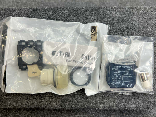 Factory-sealed bag contains white bezel unit, contact block, and separate Cutler-Hammer labeled component bag; blue spec label visible.