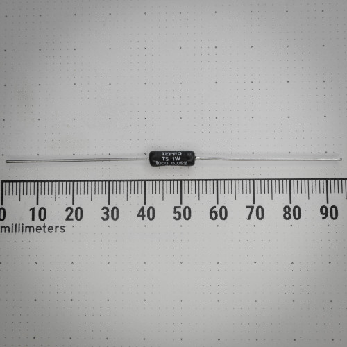 Axial precision resistor with a black molded body and silver through-hole leads, featuring white printed text that identifies it as "TEPRO TS 1W 1000 Ω 0.05%," displayed against a white background with a millimeter ruler for scale.