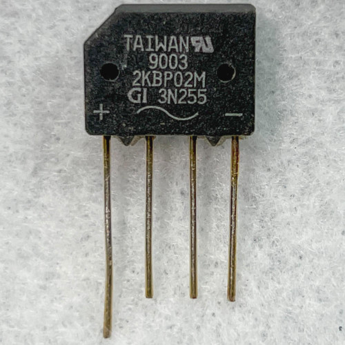 Black molded SIP-4 body marked TAIWAN, 9003, 2KBP02M, GI 3N255; + and - polarity symbols visible. Four leads show light oxidation.