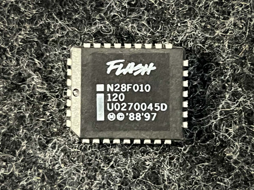 Intel N28F010-120 1024K x8 CMOS Flash Memory PLCC-32 from PartsMine.com, top view of a square black integrated circuit labeled “Flash N28F010 120 U0270045D © ’88 ’97,” shown against a textured background.