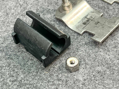 Close view of split black polymer cushion beside hex nut with nylon insert