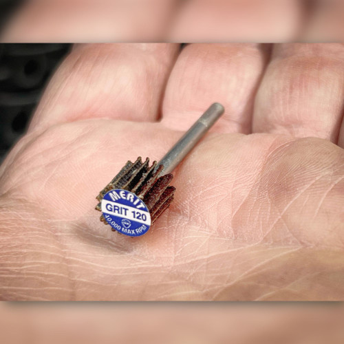 Merit 08834137472 120 grit shank-mounted mini flap wheel held in hand showing end label markings.