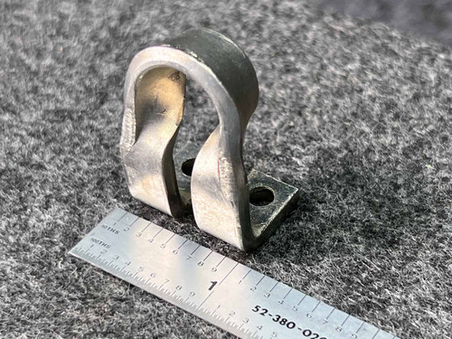 Westinghouse BZ71 Thermal Overload Heater Element BZ71, a sturdy silvertone metallic electrical control component featuring a distinctive doublecurved, Ushaped design with two flat mounting tabs, each containing a predrilled hole. The industrial part displays a brushed metal finish and is photographed against a dark gray textured surface with a ruler providing scale, highlighting its compact size for easy identification as a replacement or vintage heater element.