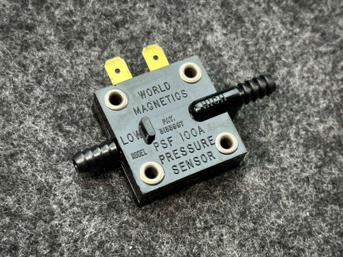 A World Magnetics pressure switch PSF100A from PartsMine.com, with visible "LOW" and "PRESSURE SENSOR" labeling, displayed on a gray textured background.
