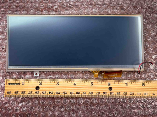 Approximately 8-inch panel with visible flex cable and small connector board; ruler confirms ~8" width. Screen surface unmarked.