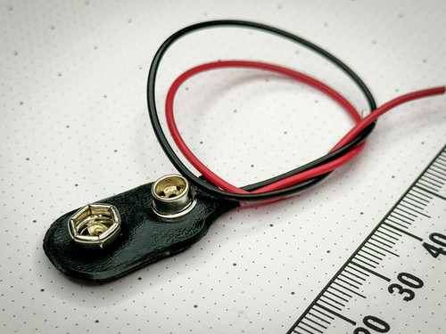 Low profile 9V battery snap connector with 26AWG red and black leads shown against a measurement scale.