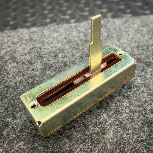 Close-up of a vintage Japan-made Alps slide fader potentiometer 10K Ohm DX2 from PartsMine.com. The metal housing and vertical sliding lever are visible.