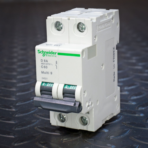 Angled view of Schneider Electric Multi 9 C60 D 8A breaker showing Merlin Gerin side embossing and Made in France