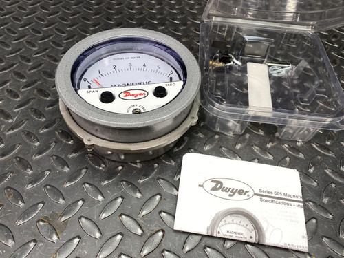 Brushed aluminum case with MAGNEHELIC and Dwyer branding on dial face; pointer at zero; ZERO and SPAN labels visible on lower dial.
