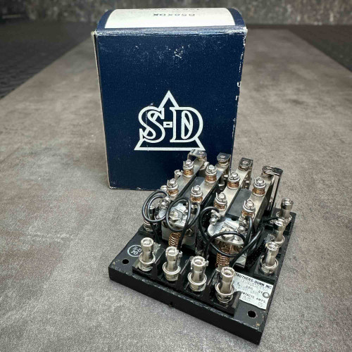 Struthers Dunn B58XDX relay standing in front of worn blue S-D logo box