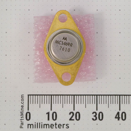 Vintage Motorola MC1469R Positive Voltage Regulator in a TO-66 metal can package with a gold-colored mounting flange and two mounting holes. The silver-colored top of the can is marked with the Motorola logo, "MC1469R," and the code "7610.