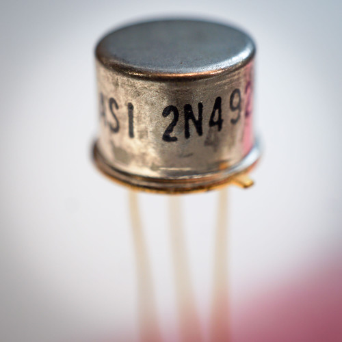 Close-up of the ASI 2N4924 NPN transistor in a TO-39 metal can showing the model number and gold leads.
