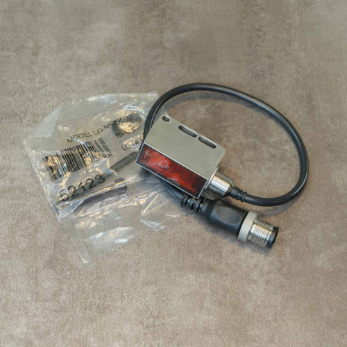 Banner sensor 316L SS housing and M12 connector clean, no visible wear. Plastic bag shows partial label "MODEL LO MO" and "52123".