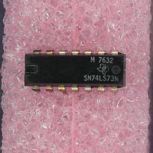 Texas Instruments SN74LS73N DIP-14 IC showing part number M 7632. Pins show slight age-related tarnishing.