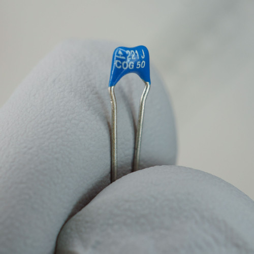 Blue epoxy body marked "221 J / COG 50"; leads straight, unformed, bright with no oxidation.