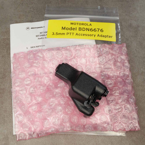 BDN6676 adapter with intact PTT latch, black textured body, no visible wear; includes original manual and anti-static bubble wrap in sealed poly bag.