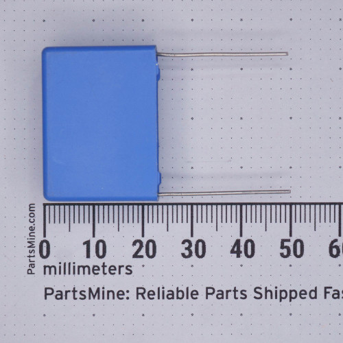 Blue box-style film capacitor with two straight radial leads; body approximately 18mm wide per ruler. No markings visible on the face shown.