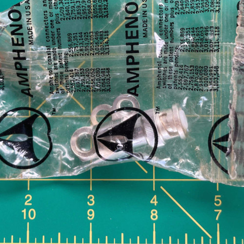 Bright nickel-plated body with knurled coupling ring and protruding white dielectric insulator nose visible. Lug washer included. No visible damage.