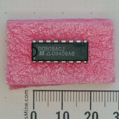 Top view of Siliconix DG508ACJ 16-pin DIP IC in pink foam with metric scale.