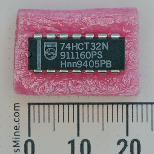 Top view of Philips 74HCT32N DIP-14 IC on pink foam with metric ruler.
