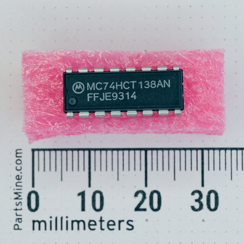 Motorola MC74HCT138AN 16-pin DIP integrated circuit on pink foam with millimeter ruler.