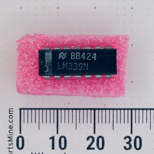 Top view of a National Semiconductor LM339N 14-pin DIP IC on pink foam with a metric scale.