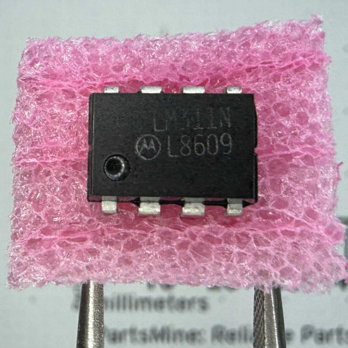 Top view of a Motorola LM311N 8-pin DIP integrated circuit in pink foam.