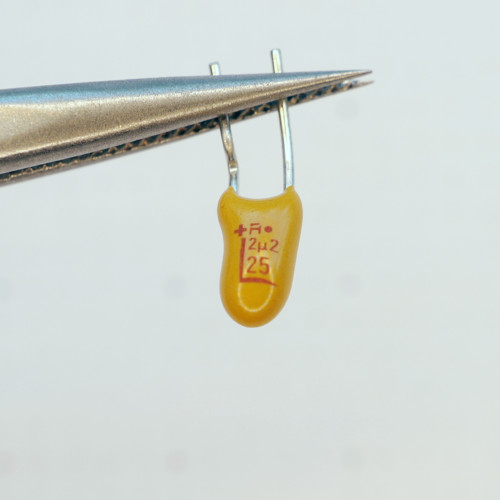 Front view of yellow dipped tantalum capacitor showing 2μ2 25V markings.