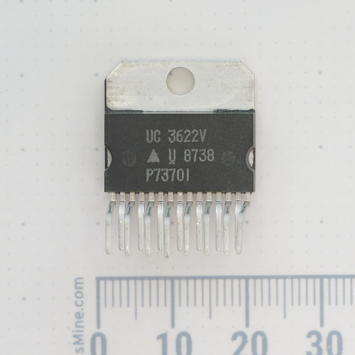 Front view of a Unitrode UC3622V 15-lead power IC on a measuring grid.