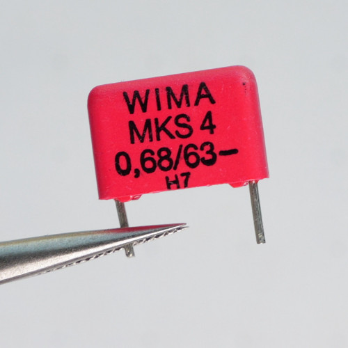 WIMA MKS4-0.68/63 capacitor held in tweezers showing front markings.
