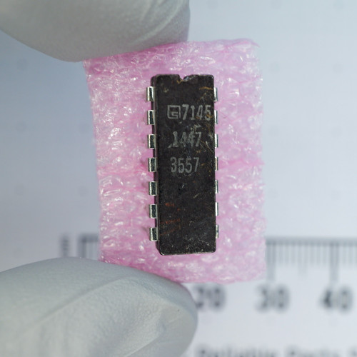 Top view of Signetics 1447-3557 14-pin DIP IC on pink foam.