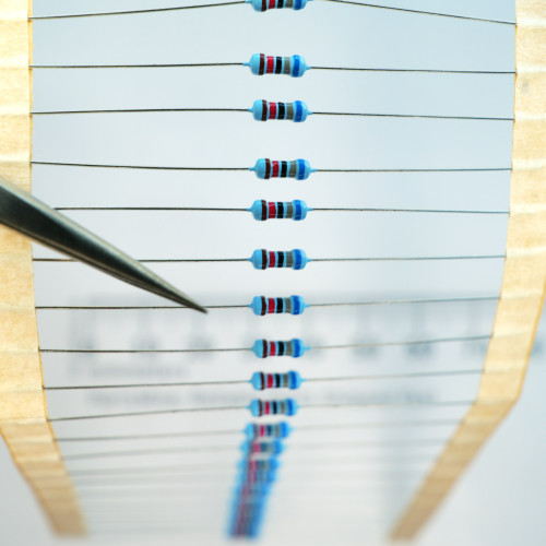 Band of axial through-hole 68k ohm resistors mounted on paper tape.