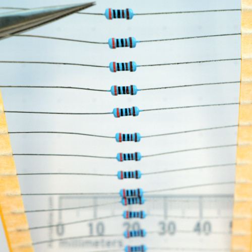 Unbranded 3K-.25W-R axial resistors on tape strip shown against a metric scale.